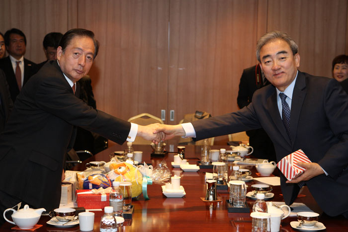  Minister Yoo Jinryong (right) shakes hands with Minister Akihiro Ota after their meeting. 
