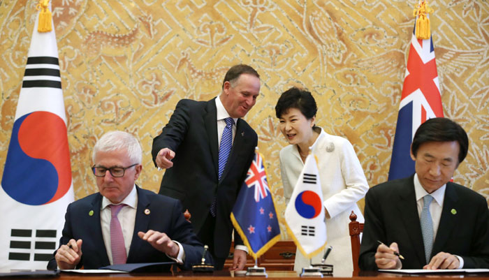 Korean Minister of Foreign Affairs Yun Byung-se (right, front) and New Zealand Minister of Trade Timothy Groser (left, front) officially sign the FTA, with President Park Geun-hye(right, back) and New Zealand Prime Minister John Key present.