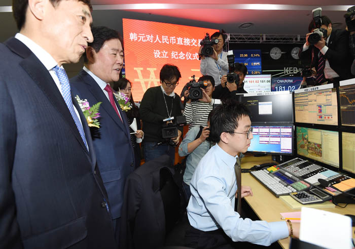 Finance Minister Choi Kyung-hwan (second from left) and Bank of Korea Governor Lee Ju-yeol (far left) watch as direct won-yuan trades begin. 