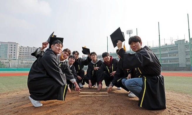 Graduating seniors on baseball team pose on pitcher's mound