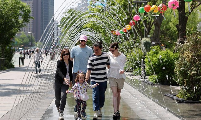 French family walks through cool fountain tunnel