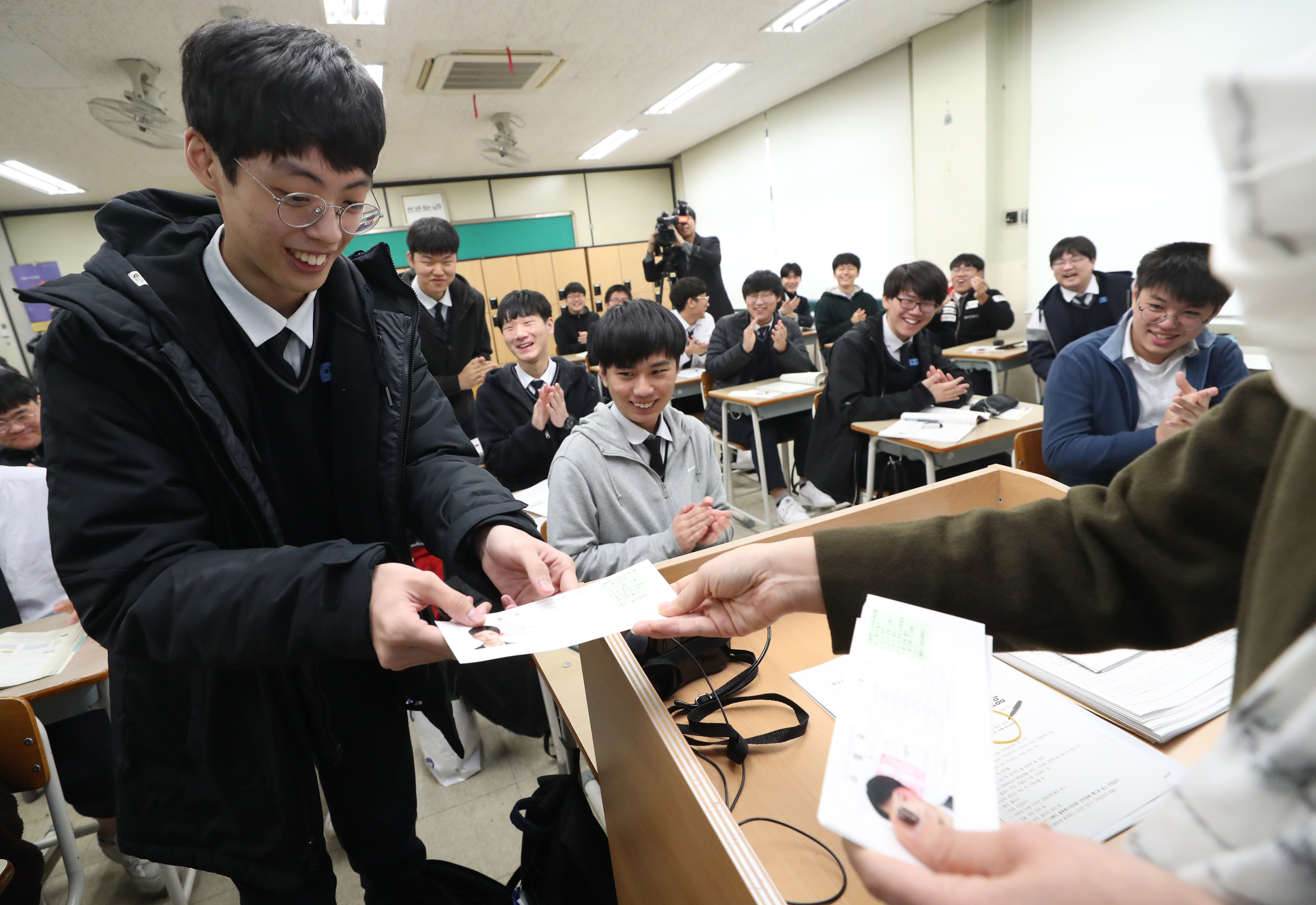 High school students on Nov. 13 receive their identification slips the day before this year's College Scholastic Ability Test. (Yonhap News)