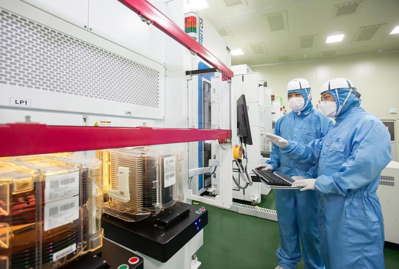 Information and communications technology exports last month set a record high for January. The photo shows a staff member from Samsung Electronics (left) and another from EO Technics inspecting semiconductor laser facilities that both companies jointly developed. (Samsung Electronics)