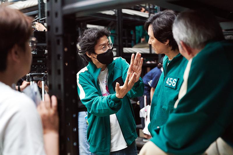 ▲ 넷플릭스 오리지널 드라마 '오징어 게임'을 만든 황동혁 감독(가운데)이 코리아넷 선정 '2021년 세계를 빛낸 한국인'에 뽑혔다. 사진은 ‘오징어 게임’ 촬영 현장에서 황동혁 감독이 배우 이정재(오른쪽에서 두 번째)와 대화하는 모습. 넷플릭스