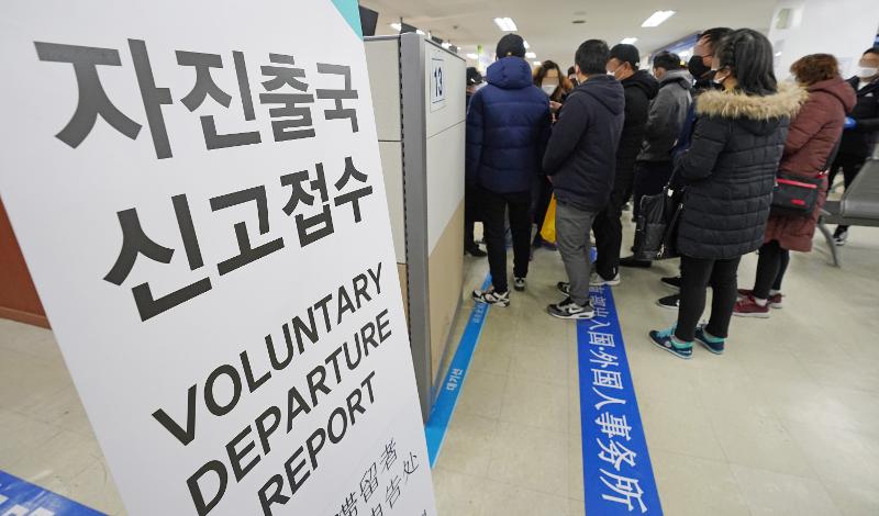 Foreign nationals staying illegally in Korea in March 2020 wait in line at the southern Seoul office of the Korea Immigration Service to report their voluntarily departure from the country. (Yonhap News) 