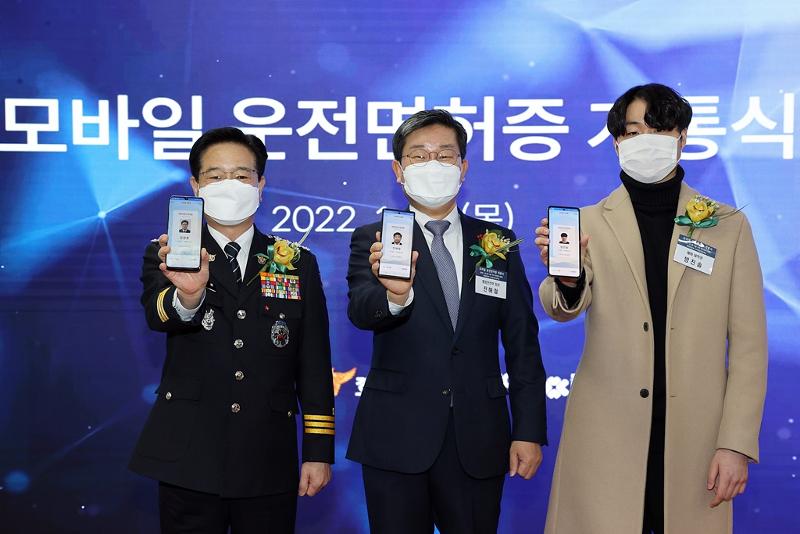 Minister of the Interior and Safety Jeon Hae-cheol (middle), Korea National Police Agency Commissioner-General Kim Chang Yong (right) and college aspirant Bang Jin-sol display their mobile driver's licenses after getting them issued.