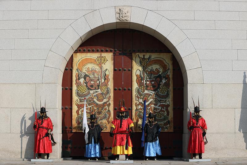 Royal guards at Gyeongbokgung Palace in Seoul's Jongno-gu District on Jan. 27 stand in front of Gwanghwamun Gate, which has hanging on it two munbaedo paintings.