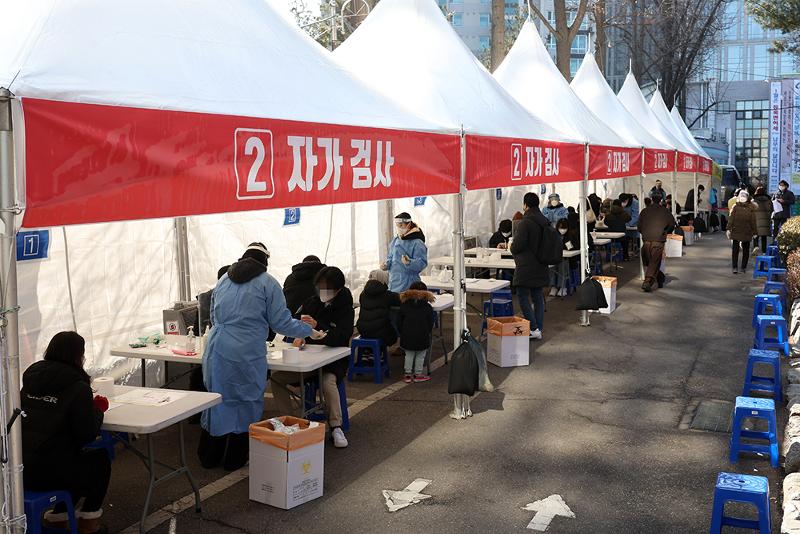 People on Feb. 3 use self-diagnostic kits to test for COVID-19 at a rapid antigen testing center within a screening clinic at the public health center of Seoul's Gwangjin-gu District.