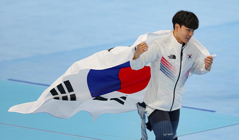 ▲ Kim Min-seok on Feb. 8 waves the national flag at the 2022 Beijing Winter Olympics after winning the bronze medal in the men's 1,500-m race at the National Speed Skating Oval in the Chinese capital. (Yonhap News) 