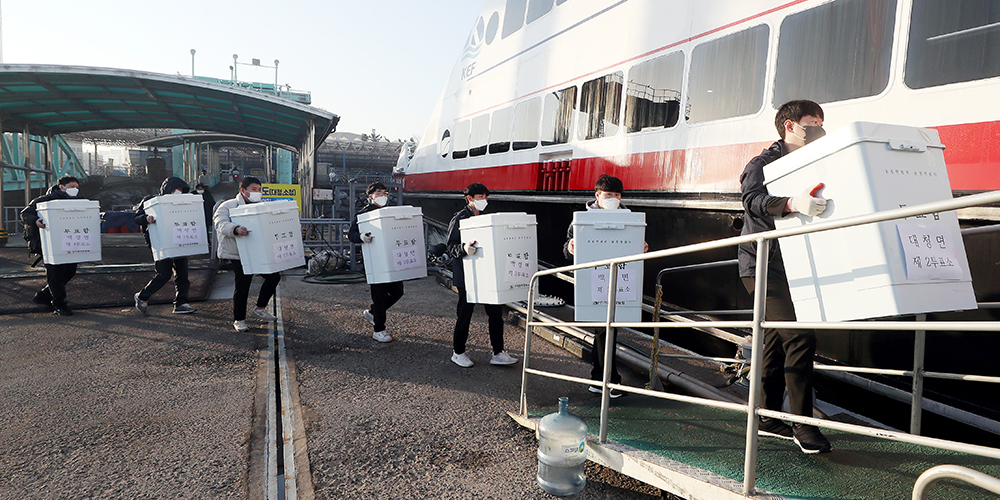 Officials from the Incheon branch of the National Election Commission on March 3 load ballot boxes