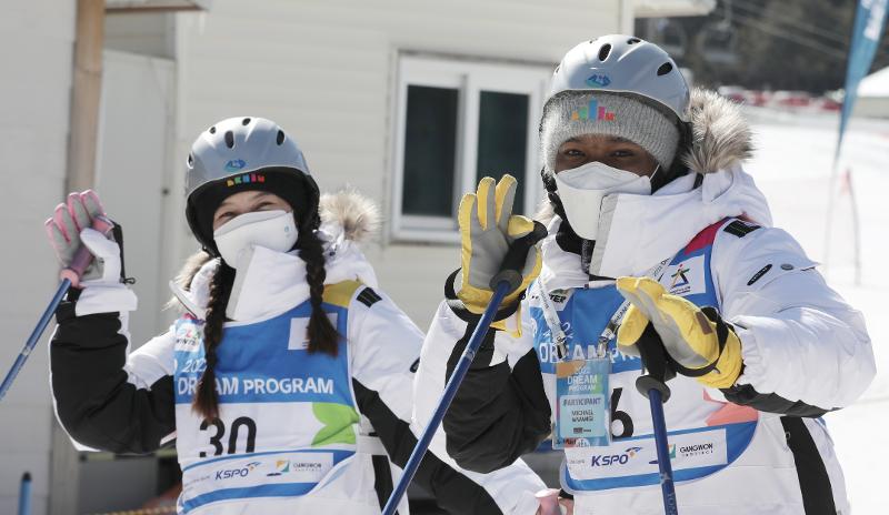 Michael Chege Mwangi (right) from Kenya on Feb. 23 participates in the Dream Program by skiing at Yongpyong Resort in Pyeongchang-gun County, Gangwon-do Province
