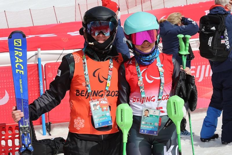 Choi Sara (right), the youngest member of Team Korea at age 19, on March 12 poses for photos with her guide runner Kim Yoo-seong after completing the women's slalom vision impaired competition at the Yanqing National Alpine Skiing Centre. After competing in her first Winter Paralympics, a confident Choi said, 