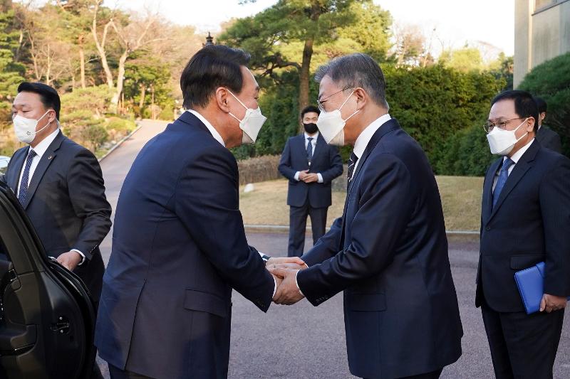 President Moon Jae-in (right) on March 28 greets President-elect Yoon Suk Yeol before their dinner at the guesthouse Sangchunjae of Cheong Wa Dae. 