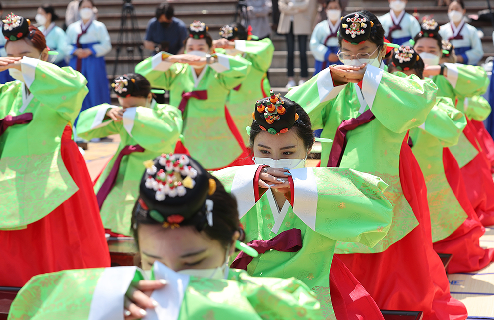 Young women born in 2003 and wearing the ceremonial upper garment dangui on the morning of May 16 take part in a reenactment of a traditional ceremony for Coming of Age Day. 