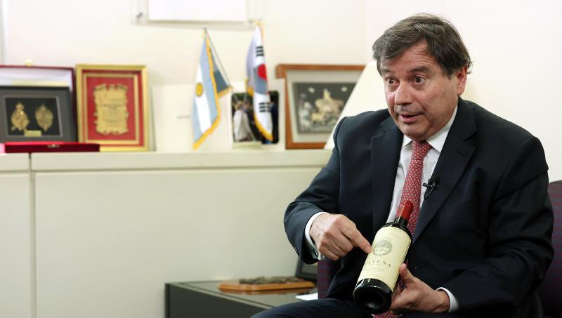Argentine Ambassador to Korea Alfredo Carlos Bascou introduces an Argentine wine during the May 17 interview with Korea.net. He said Catena, the wine he was holding, can be found only at the Argentine Embassy in Korea, with the logo on the bottle being the Latin American country's official national emblem.