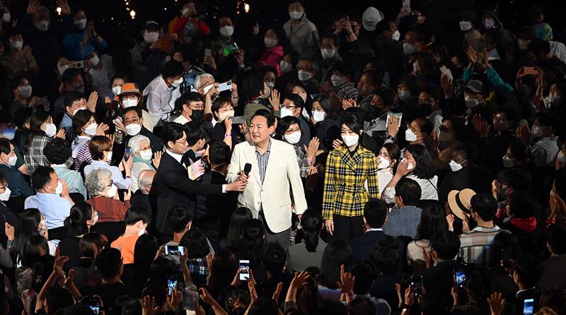 President Yoon Suk Yeol and first lady Kim Keon-hee on May 22 greet the audience on the outside stage of the main garden at Cheong Wa Dae during a commemorative edition of 