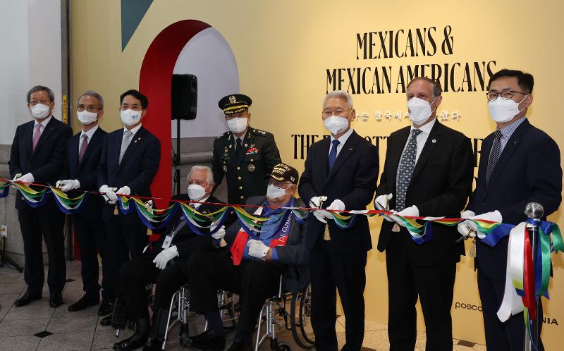 Mexican veterans on June 28 pose for photos with people attending the opening ceremony before cutting the ribbon to officially open the exhibition 