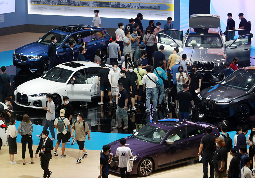 Visitors at the Busan Exhibition and Convention Center, or BEXCO, on July 15 look at cars on display at the 2022 Busan International Motor Show in Busan's Haeundae-gu District. The biennial event is being held for the first time in four years after the 2020 edition was canceled due to COVID-19. To run through July 24, the show features 120 companies from eight countries including six automakers.