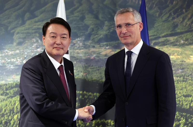 President Yoon Suk Yeol, who visited Madrid, Spain, to attend the North Atlantic Treaty Organization (NATO) summit, on June 30 shakes hands with NATO Secretary General Jens Stoltenberg at IFEMA Convention Center before holding talks. (Yonhap News)