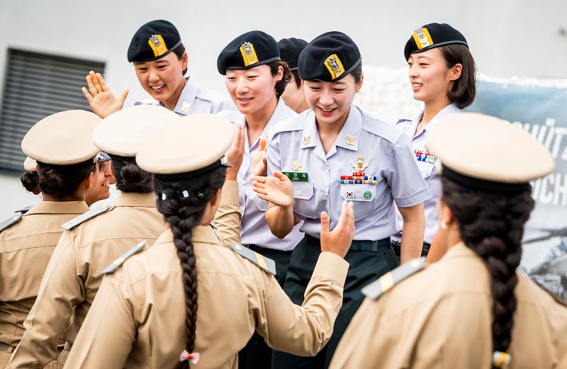 Four female soldiers from the Republic of Korea Army's Special Warfare Command, who won the gold medal in four-way formation skydiving at the 45th World Military Parachuting Championship (WMPC) in Gussing, Austria, on July 29 hi-five members of runner-up Morocco. (Official homepage of 45th WMPC