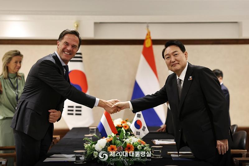 President Yoon Suk Yeol (right) on June 29 shakes hands with Dutch Prime Minister Mark Rutte at a Madrid hotel before their bilateral summit.