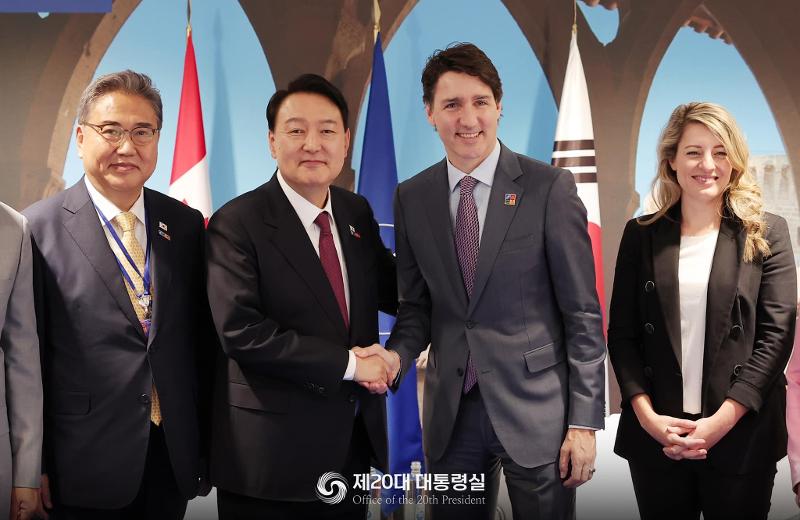 President Yoon Suk Yeol (second from left) and Canadian Prime Minister Justin Trudeau (second from right) on June 30 shake hands at IFEMA Convention Center before their bilateral summit.