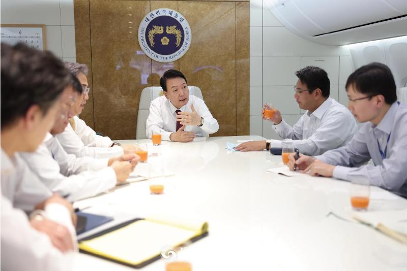 President Yoon Suk Yeol on June 30 holds a meeting with his advisers on the presidential plane Code One while flying back from Madrid to Seoul Air Base in Seongnam