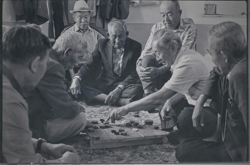Elderly Goryeoin men play janggi (Korean chess) at Sandmak, a home for the elderly in the village of Kuilyuk in Tashkent, Uzbekistan, in a photo taken in 1991. Unlike the Korean card game hwatu (Go-Stop) janggi is said to be disappearing among Goryeoin as mostly senior citizens play it. (National Folk Museum of Korea)
