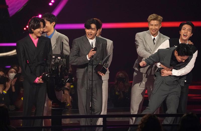 Members of BTS on Nov. 21, 2021, celebrate after winning Artist of the Year at the 49th American Music Awards held at Microsoft Theater in Los Angeles. (Yonhap News)
