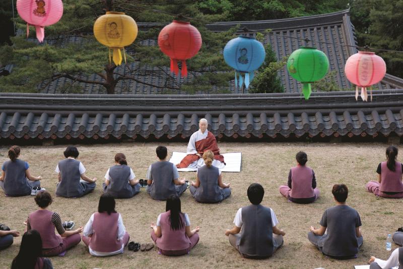 Launched in 2002, the Buddhist templestay project attracted more than six million people over the last two decades, with 11% of those attending coming from overseas. Shown are participants practicing meditation with a monk. (Cultural Corps of Korean Buddhism) 