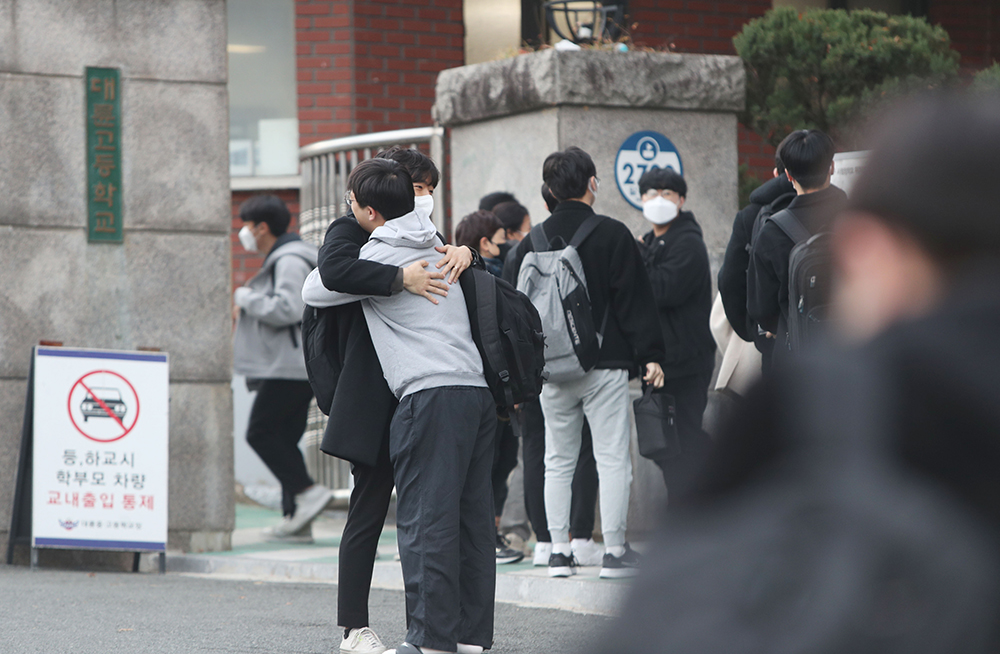 Students on the morning of Nov. 17 in Daegu's Suseong-gu District hug their family members before entering the exam center at Daeryun High School to take the annual College Scholastic Ability Test (Suneung). 