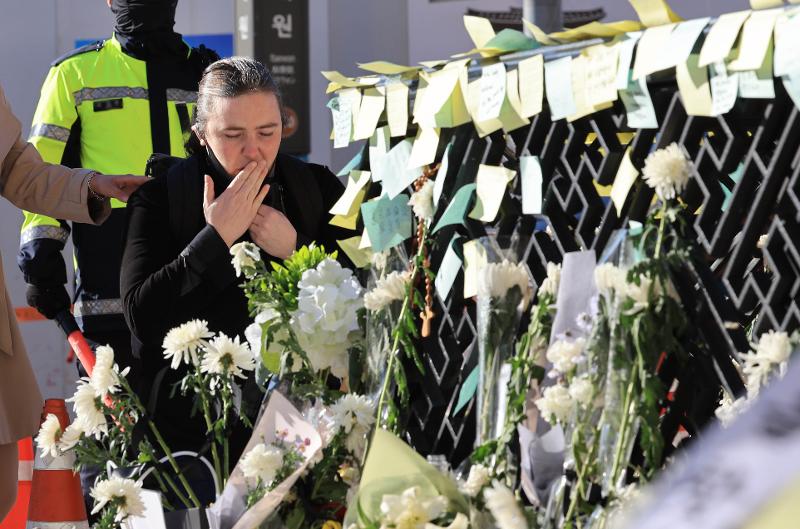 A woman on Nov. 2 pays tributes to those who died in the Itaewon incident in front of Exit 1 of Itaewon Station in Seoul's Yongsan-gu District. (Yonhap News)