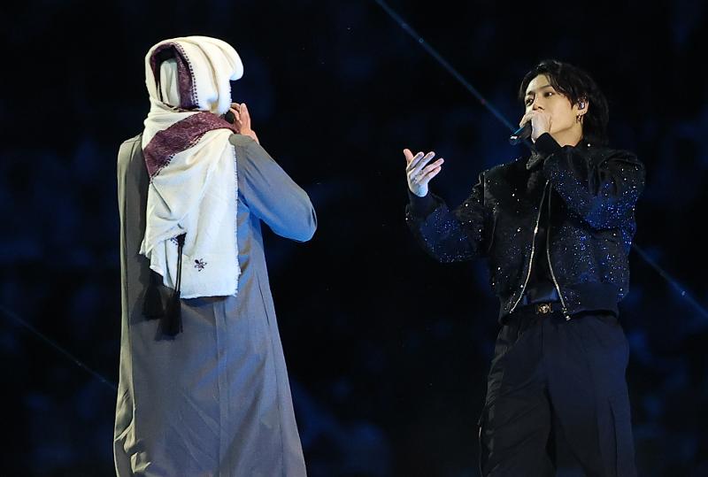 El miembro de BTS Jungkook (derecha) y el cantante qatarí Fahad Al Kubaisi el 20 de noviembre cantan la canción oficial de la Copa Mundial de este año.
