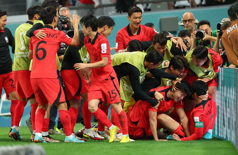 National team forward Cho Gue-sung on Nov. 28 is mobbed by teammates after his second goal tied the score against Ghana in their second Group H game of the Qatar World Cup at Education City Stadium in Al Rayyan, Qatar. 