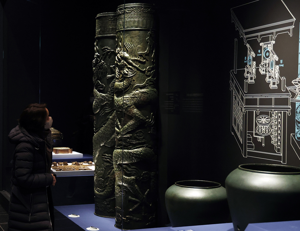 A staff member on Dec. 26 takes a look at Jagyeongnu, a clepsydra or water-using clock that automatically strikes the hour by adjusting water level, displayed at the renovated permanent exhibition hall of Scientific Achievement of the Joseon Dynasty at the National Palace Museum of Korea in Seoul's Jongno-gu District.