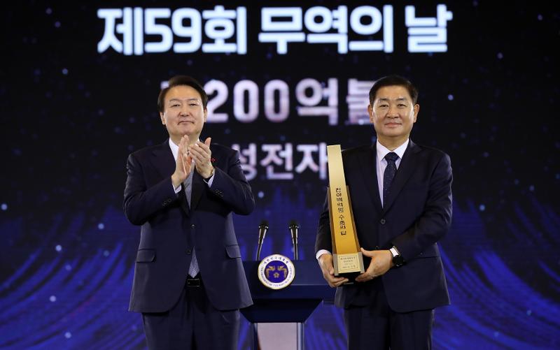 President Yoon Suk Yeol (left) on Dec. 5 takes a commemorative photo with Samsung Electronics CEO Han Jong-hee after giving the company a Trade Tower award for achieving USD 120 billion in exports at a ceremony marking the 59th Trade Day at COEX Mall in the Samseong-dong neighborhood of Seoul's Gangnam-gu District. (Yonhap News) 