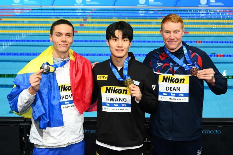 Hwang Sun-woo (center) on Dec. 18 poses at the medals ceremony after winning the gold in the men's 200-m freestyle at the FINA Short Course World Swimming Championships in Melbourne, Australia, alongside runner-up David Popovici of Romania (left) and bronze medalist Tom Dean of the U.K.