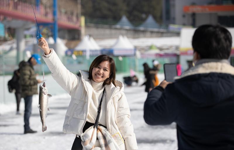 A foreign tourist at this year's Hwacheon Sancheoneo Ice Festival on the morning of Jan. 9 celebrates catching a sancheoneo (mountain trout) at Hwacheoncheon Stream in the town of Hwacheon-eup in Hwacheon-gun County, Gangwon-do Province. (Kim Sunjoo)