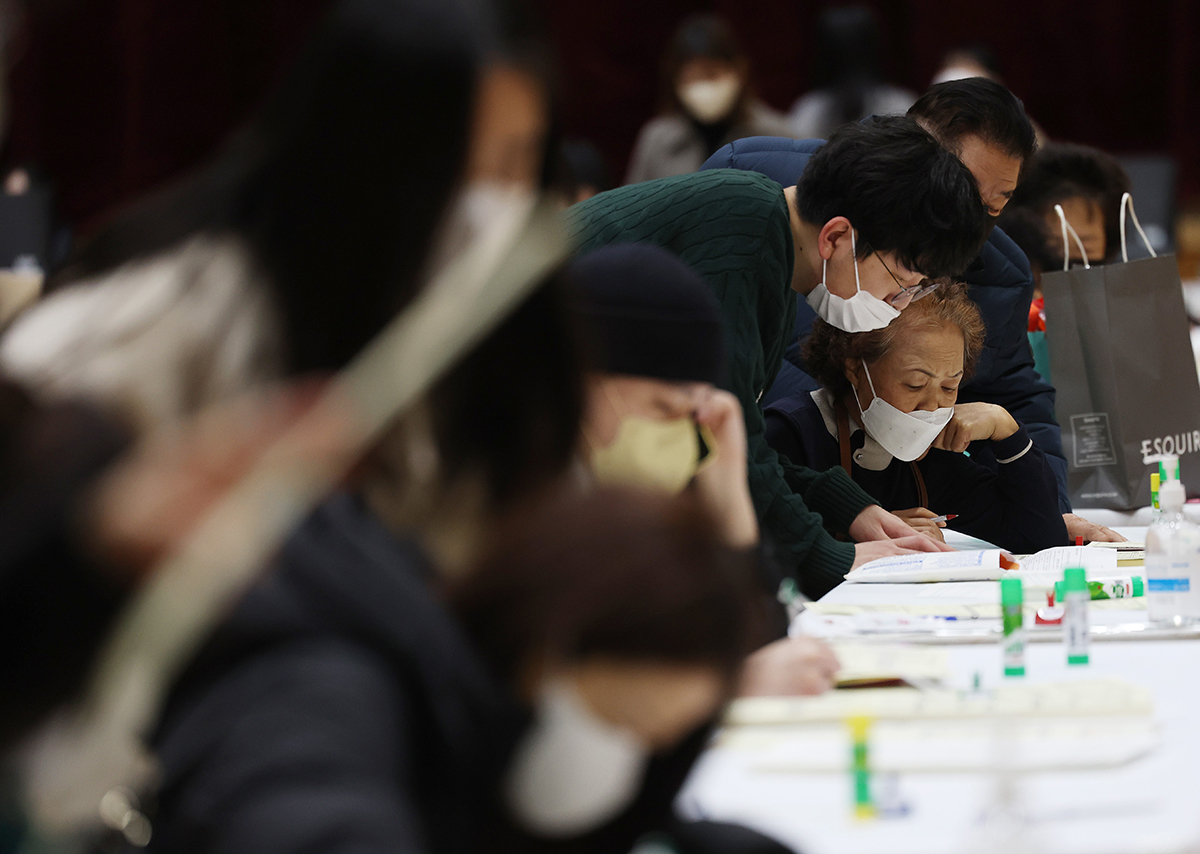 Marking the start of the application period for this year's first round of geomjeong gosi (general equivalency exams) for elementary, middle and high school diplomas, applicants on the morning of Feb. 13 fill out applications at the gym of Seoul Technical High School in the capital's Dongjak-gu District.