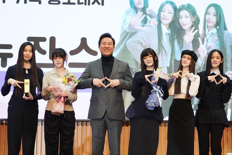 The K-pop girl group NewJeans on Feb. 16 pose for a commemorative photo with Seoul Mayor Oh Se-hoon (third from left) at a ceremony for NewJeans' appointment as the Seoul Metropolitan Government's public relations ambassador at Seoul City Hall in the capital's Jung-gu District. (Seoul Metropolitan Government)