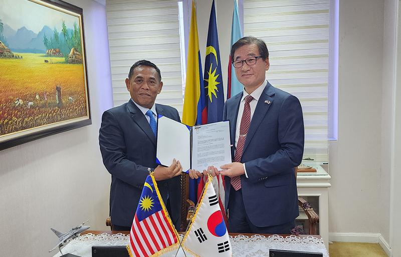 Korea Aerospace Industries (KAI) CEO Kang Goo-young (right) takes a commemorative photo with secretary general of Malaysia's defense ministry Datuk Muez bin Abd Aziz on Feb. 24 after concluding a deal to export 18 FA-50 light attack aircraft to Malaysia. (KAI)