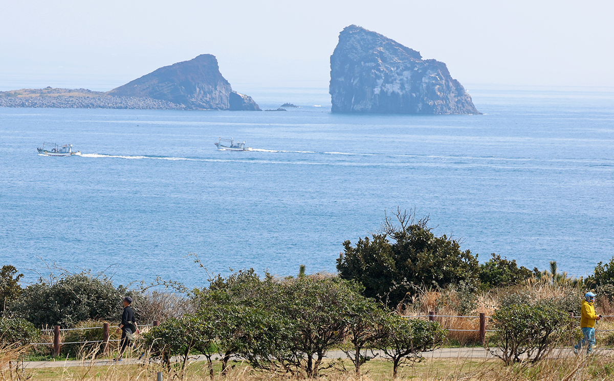Greeting Gyeongchip, or one of the nation's 24 solar terms when frogs awake from their hibernation, visitors on March 6 enjoy spring weather while walking along the trail Dulle-gil around Songaksan Mountain in the township of Daejeong-eup in Seogwipo, Jeju Island.