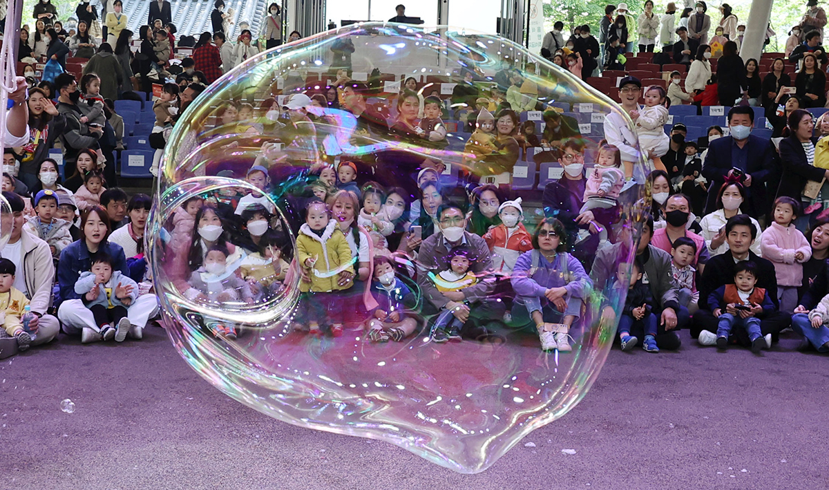 Children and their parents on the morning of April 27 watch a soap bubble performance at a festival hosted by Songpa-gu District Office at the performing arts venue Seoul Nori Madang in the capital's Songpa-gu District.