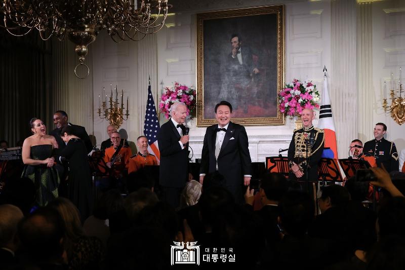 President Yoon Suk Yeol on April 26 shows a big smile flanked by U.S. President Joe Biden at a performance for a state dinner at the White House in Washington.