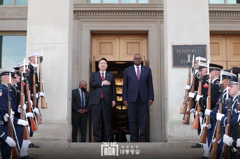 President Yoon Suk Yeol (left) and U.S. Secretary of Defense Lloyd Austin (right) on April 27 salute their nation's flags at the Pentagon in Arlington, Virginia, as honor guards perform the national anthems of both countries.
