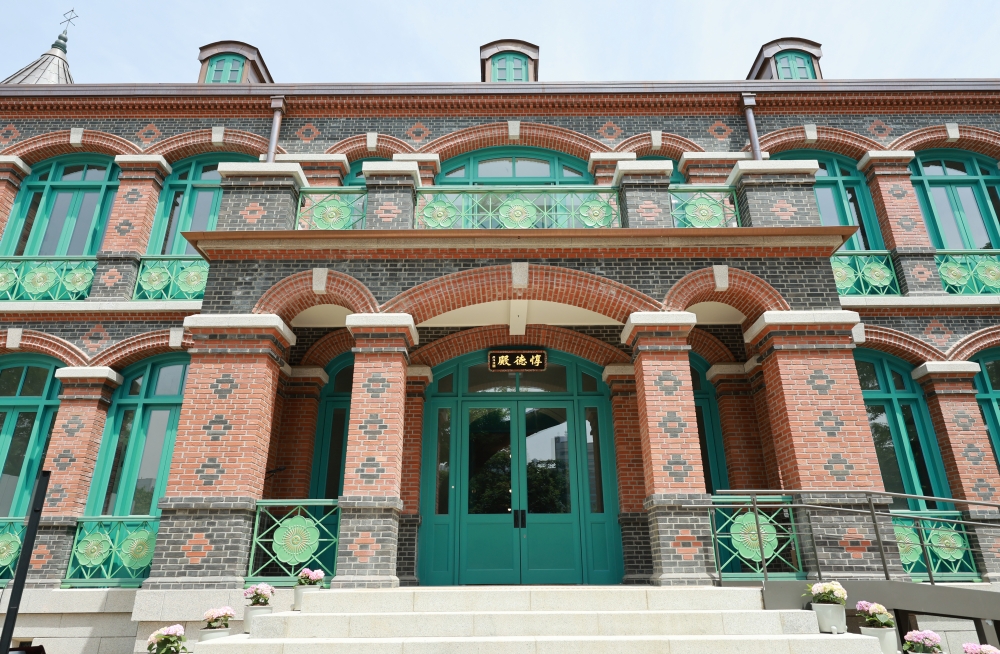 The exterior of the reconstructed Dondeokjeon features red bricks, blue window frames, a balustrade engraved with plum flowers that symbolized the royal family and conical spires. 