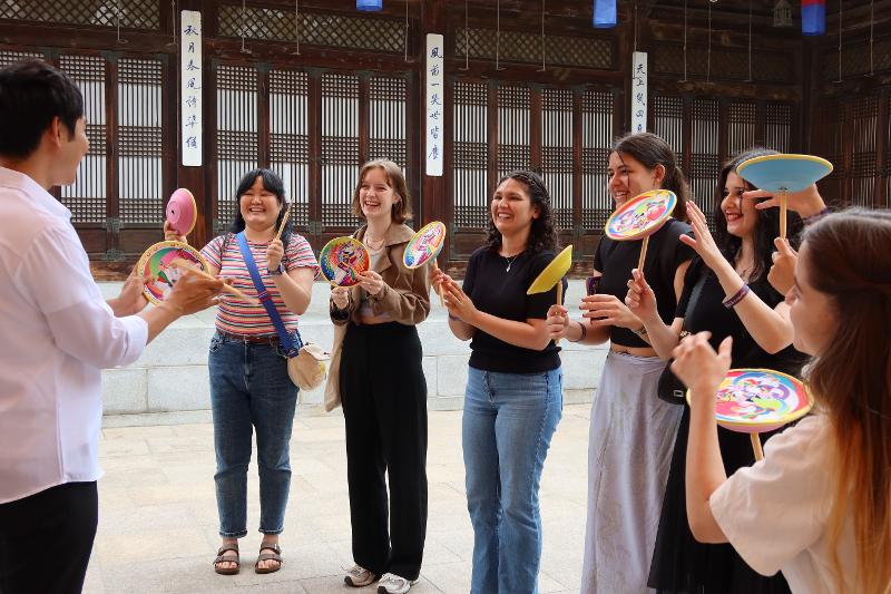 Foreign visitors on the afternoon of June 12 participate in the program (The Senses of K-Culture,) trying beonadolligi, a traditional game using wooden sticks to spin bowls, treadwheels or basins, at Korea House in Seoul's Jung-gu District.