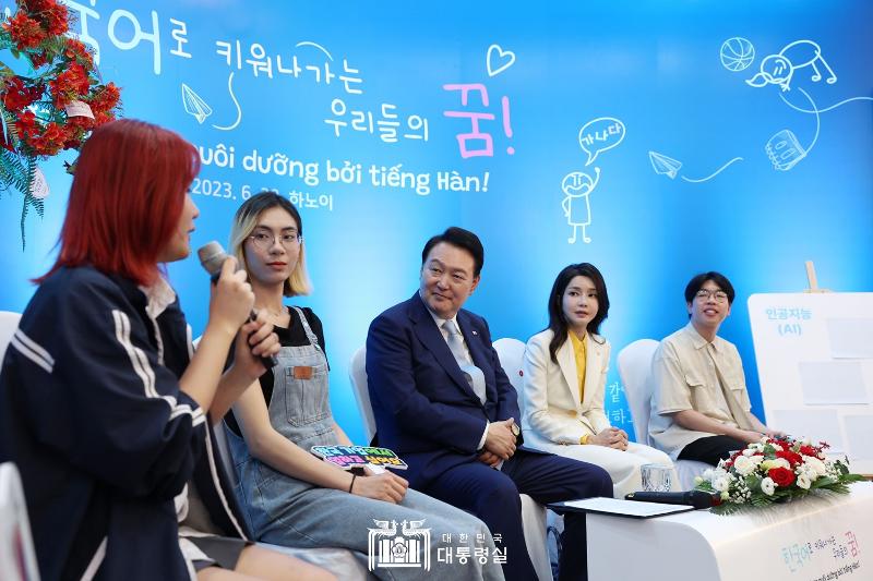 President Yoon Suk Yeol (third from left) and first lady Kim Keon Hee (fourth from left) on June 22 speak at a dialogue with Vietnamese students of the Korean language at Vietnam National University in Hanoi. 