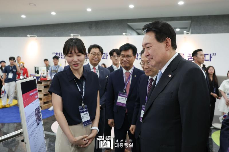 President Yoon Suk Yeol on July 5 listens to a visiting young scientist at the promotional booth of a participating country at the inaugural World Congress of Korean Scientists and Engineers held at the Korea Science and Technology Center in Seoul's Gangnam District.