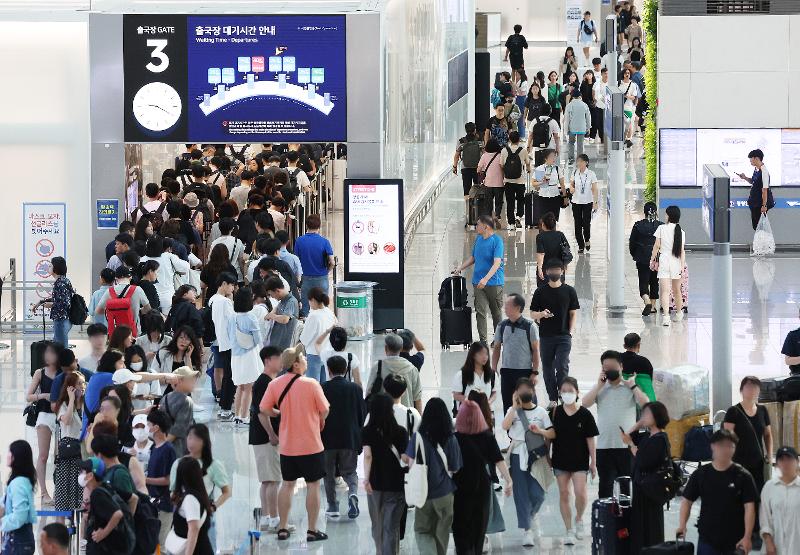 Starting from early August, the government will begin the second phase of its risk management roadmap for COVID-19. The photo shows the departure area of Terminal 1 at Incheon International Airport on the morning of July 20, bustling with tourists without protective masks. (Yonhap News) 